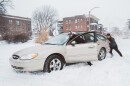 A man pushes a car stuck in deep snow as another driver steers on Sunday, Jan. 25, 2026, in St. Louis’ Shaw neighborhood. A winter storm brought nearly a foot of snow and icy conditions across the region, prompting hazardous travel conditions, closed schools and government offices.
