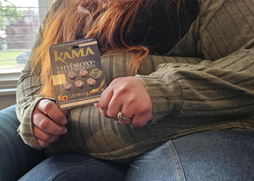 A woman in a green sweater is shown holding a 7-OH package, called "Kama." Her face is not shown, but her reddish brown air is visible, along with a ring on her left hand.
