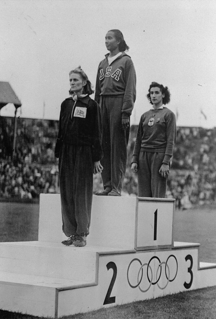 Alice Coachman stands on the winner's section of the Olympic podium at Wembley Stadium in 1948.