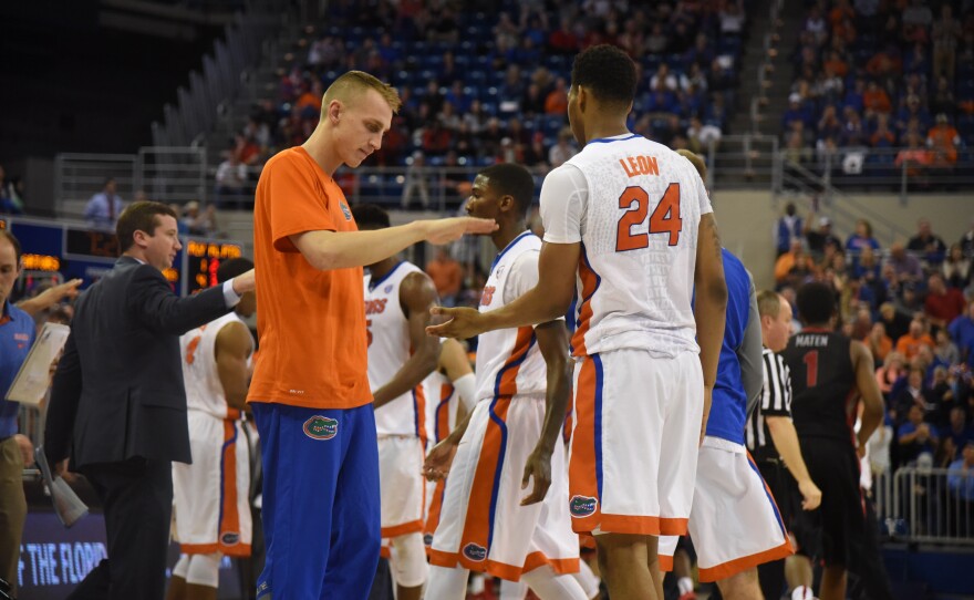 As time expires and the Gators secure the win, Alex Murphy congratulates teammate Justin Leon (24). (Greenberry Taylor/WUFT News)