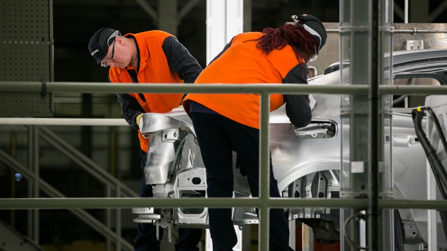 Workers inspect a Volvo S60 sedan's body on June 20, 2018. Robotic sensors examine welds, but human hands and eyes assess the touch and feel of the metal.
