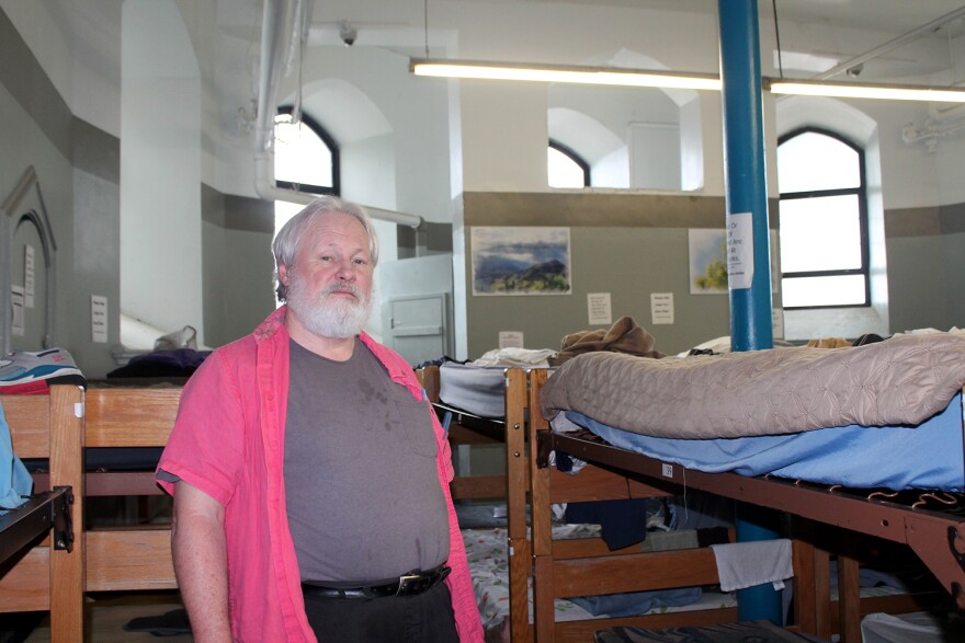 Tom Burnham stands among the bunk beds in the basement of St. Peter and Paul Catholic Church, where Peter and Paul Community Services operates an emergency shelter for men.