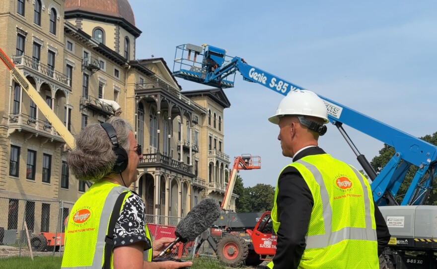 Father Luke Strand talks with WUWM's Susan Bence outside Henni Hall.