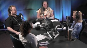 Four members of the WFSU news team are seated at a large table with microphones