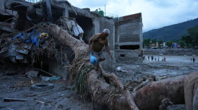 A resident salvages belongings from his damaged home after flash flooding in the Devighat area of Nuwakot district in Nepal, Monday, Aug. 31, 2026.