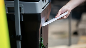 A voter drops off a ballot at the Travis County Tax Office, the only site where mail-in ballots can be hand delivered in the county.