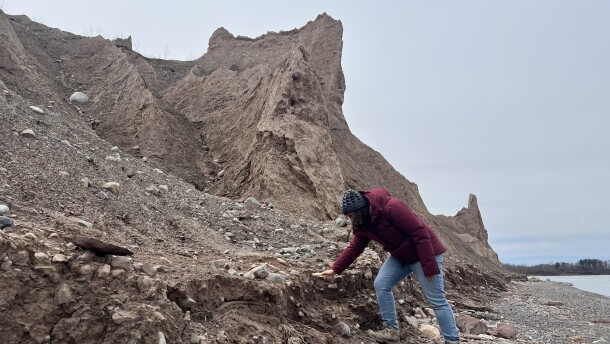 Rachel Glade, a geomorphologist and assistant professor at the University of Rochester, explores the make up of glacial till at the base of the Chimney Bluffs.