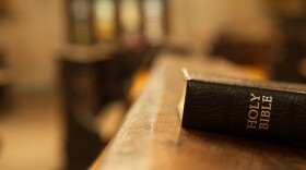 Holy Bible on a wooden church bench.
