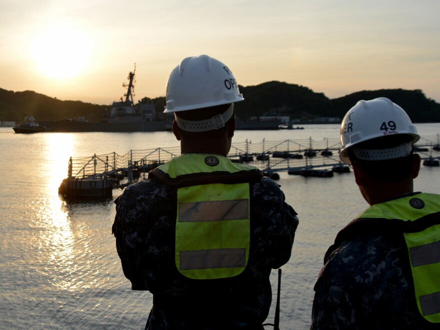 Sailors watch pier-side as the Arleigh Burke-class guided-missile destroyer USS Fitzgerald (DDG 62) returns to Fleet Activities (FLEACT) Yokosuka following a collision with a merchant vessel while operating southwest of Yokosuka, Japan.