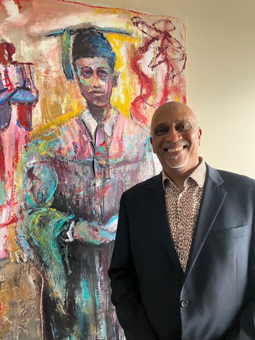 Preston Sampson stands next to another of his paintings in a Modern Woodmen Park suite March 26, 2026.