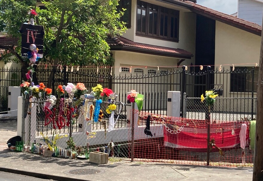 FILE - Floral bouquets, deflated balloons, candles and other items decorate a street memorial by the Kalakaua Canal where Honolulu Police shot and killed 16-year-old Iremamber Sykap during a car chase on Kalakaua Ave., in Honolulu, April 28, 2021.