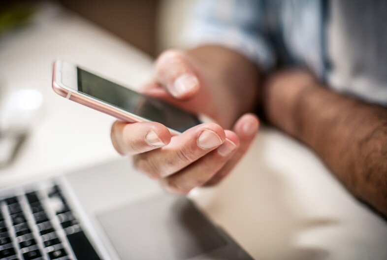 A man holds a cell phone in his hand.