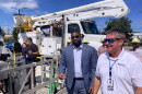 Two men standing outside next to a bucket truck
