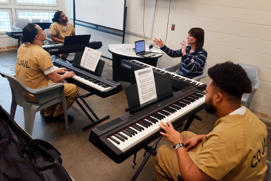 Three detainees listen to instructor Joe Zempel during the last day of the piloted Melodies of Hope piano class at the Buzz Westfall Justice Center on May 19 in Clayton.