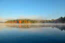 A lake with morning fog in fall.