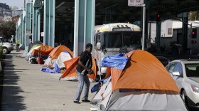 In this Feb. 23, 2016 file photo, a man stands outside his tent on Division Street in San Francisco. (Eric Risberg, File/AP)