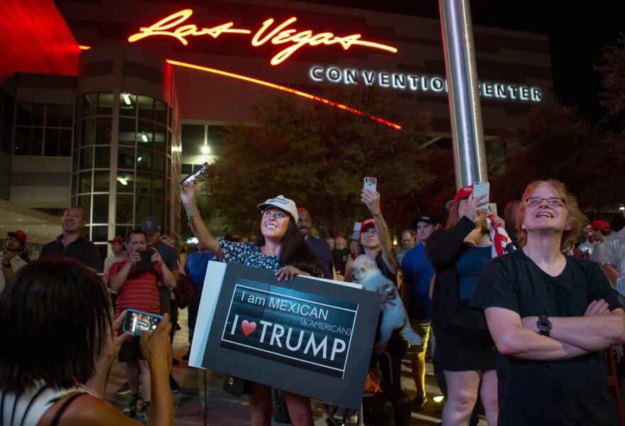 Supporters gather outside the Las Vegas Convention Center as they watch President Trump's rally on screens in the parking lot on Sept. 20.