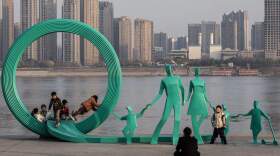 This photo taken on January 5, 2024 shows people posing next to a newly renovated statue of a pair of parents and three children in Hankou Park next to Yangtze River in Wuhan, in China's central Hubei province. China's population decline accelerated in 2023, official data showed on january 17, 2024, extending a downward streak after more than six decades of growth as the country battles a looming demographic crisis. (Photo by AFP) / China OUT (Photo by STR/AFP via Getty Images)