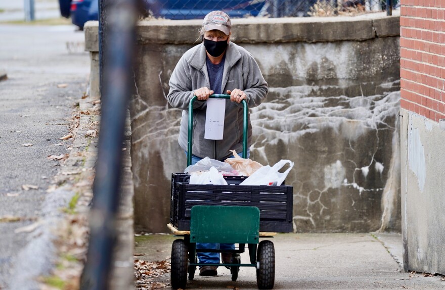 A worker at the St. Matthews Area Ministries pushes a cart of food up a ramp on Dec. 8, 2020.