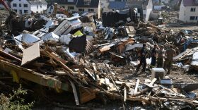 Workers walk amid debris in Kreuzberg, district of Altenahr, Rhineland-Palatinate, western Germany, during clearing work after devastating rains and floods hit the region.