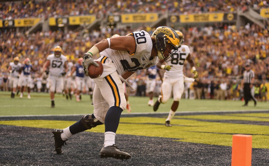 Michigan running back Drake Johnson (20) catches a 5-yard pass from quarterback Jake Rudock (15) in the begining of the fourth quarter, extending his team's lead to 38-7. (Greenberry Taylor/WUFT News)