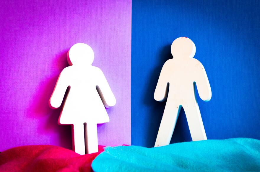 Cutouts of a woman and a man lean against a wall. Behind the woman is a purple color and behind the man is a blue color. The two colors are split down the middle between the space between the man and woman.