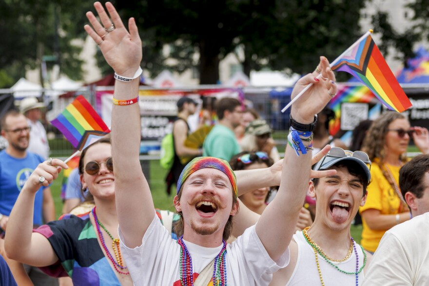 Josh Obenhaus, center, and friends cheer from the sidelines of the Grand Pride Parade on Sunday, June 29, 2025 in downtown St. Louis — his third year celebrating Pride in the city.