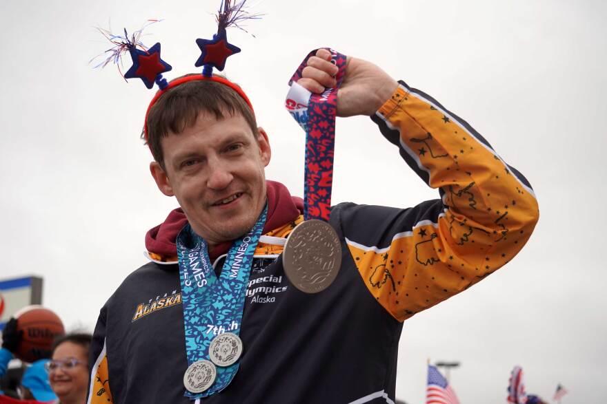 Jason Criss holds aloft his silver medal from the 2026 Special Olympics USA Games during the Independence Day parade in Kenai, Alaska, on July 4, 2026.