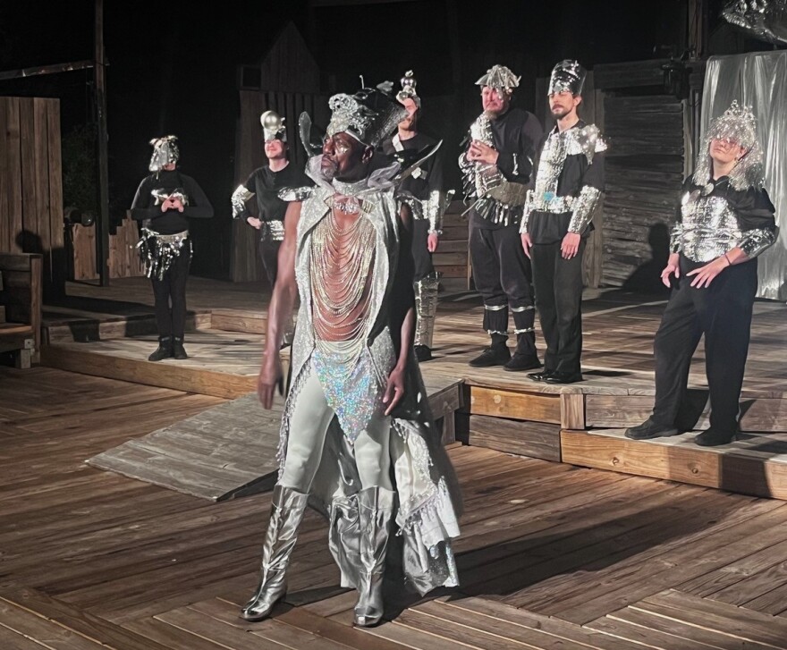Silvery tall man leads a crew of comical aliens who've come from a flying saucer