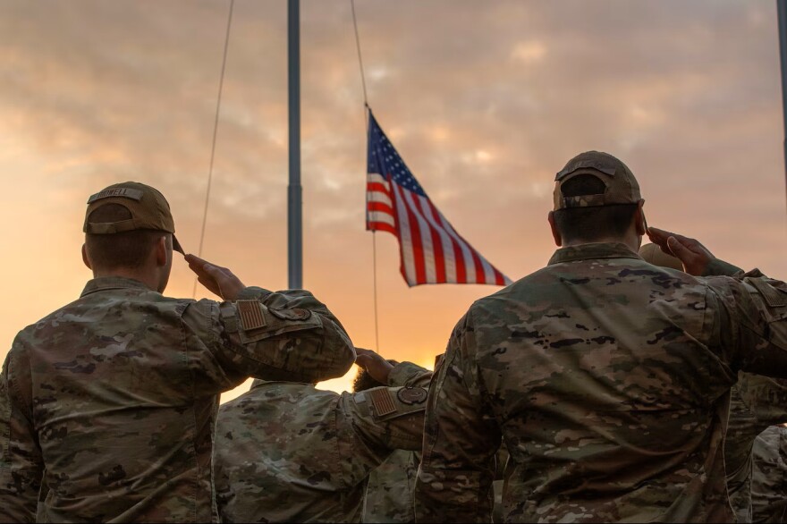 Military personnel salute during a Veterans Day retreat ceremony at Yokota Air Base, Japan, Nov. 9, 2023.