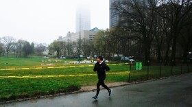 A woman jogs by Central Park as workers set up a field hospital in front of Mount Sinai West Hospital on March 29, 2020 in New York City. (KENA BETANCUR/AFP via Getty Images)