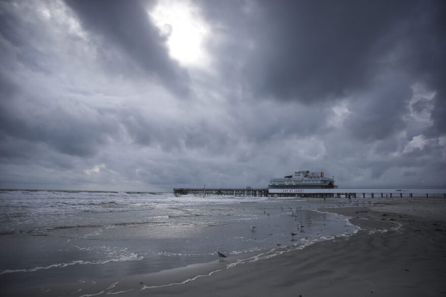 Clouds cover the sky over the beach near the Daytona Beach Boardwalk and Pier ahead of Hurricane Matthew in Daytona Beach, Fla. on Thursday, Oct. 6, 2016. Matthew steamed toward Florida with winds of 140 mph Thursday as hundreds of thousands of people across the Southeast boarded up their homes and fled inland to escape the most powerful storm to threaten the Atlantic coast in more than a decade. (Will Vragovic /Tampa Bay Times via AP)