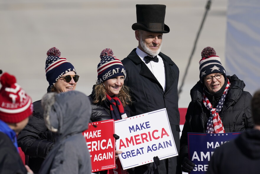 Supporters pose for photos as they wait for Vice President Mike Pence to arrive for an airport rally, Thursday, Oct. 29, 2020, in Des Moines, Iowa.