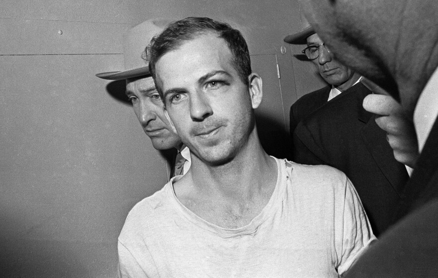 Lee Harvey Oswald is led down a corridor of the Dallas police station for questioning in connection with Kennedy's assassination on Nov. 23, 1963.