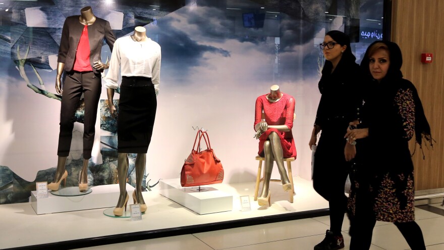 Iranian women walk past a window display in Tabriz in northwestern Iran on Oct. 15. Iran is facing a host of economic problems as world oil prices fall and international sanctions remain in place.