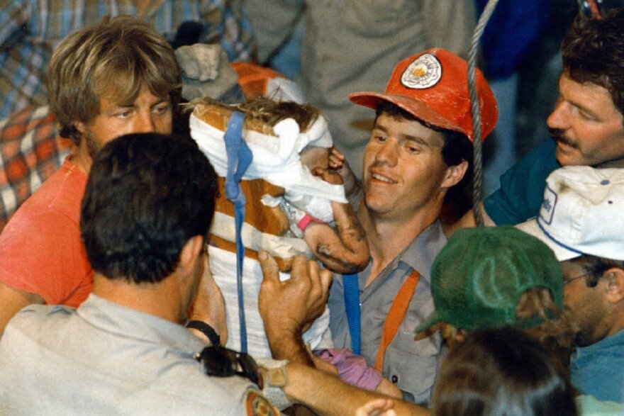 Rescue worker Steven Forbes carries 18-month-old Jessica McClure on Oct. 16, 1987, shortly after she was rescued from an abandoned water well in Midland, Texas.