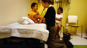Resident nurse Amy Grover checks the heart rate of a 3-year-old in the emergency room of the Children's Hospital in Aurora, Colorado.