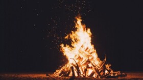 a bonfire lights up a night scene
