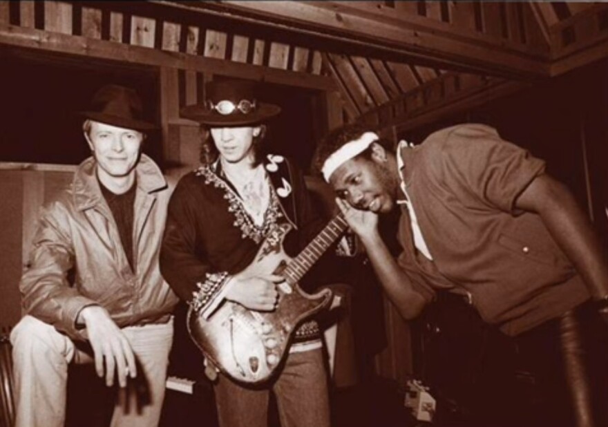  A black and white photo of David Bowie, Stevie Ray Vaughan and producer Nile Rodgers.