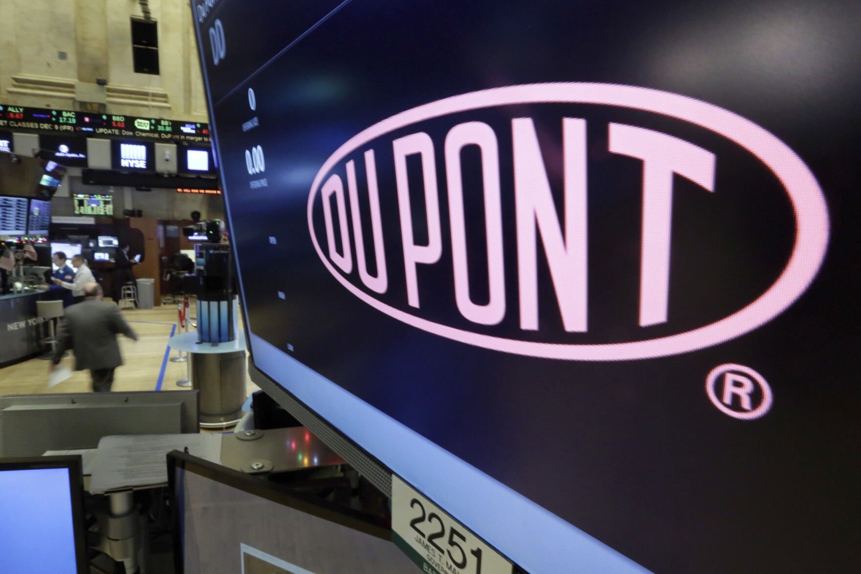 In this Dec. 9, 2015, file photo, the company name of Dupont appears above its trading post on the floor of the New York Stock Exchange. 