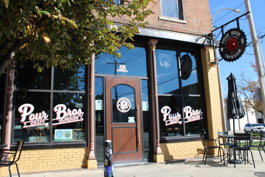 The Pour Brothers Taproom has an attractive facade with signage along the widows and an attractive sign hanging from the front of the building.
