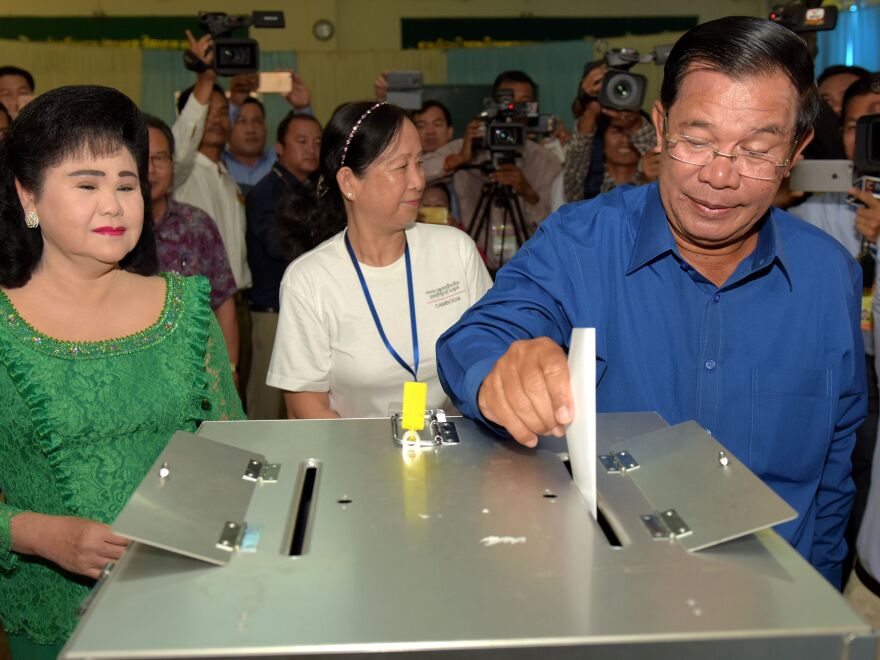 Cambodian Prime Minister Hun Sen cast his ballot as his wife Bun Rany (L) looks on at a polling station in Kandal province on June 4, 2017.