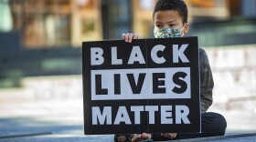 10-year-old Marcus Bilodeau holds a Black Lives Matter sign during the What this Win Means for Black Lives rally at City Hall Plaza. (Jesse Costa/WBUR)