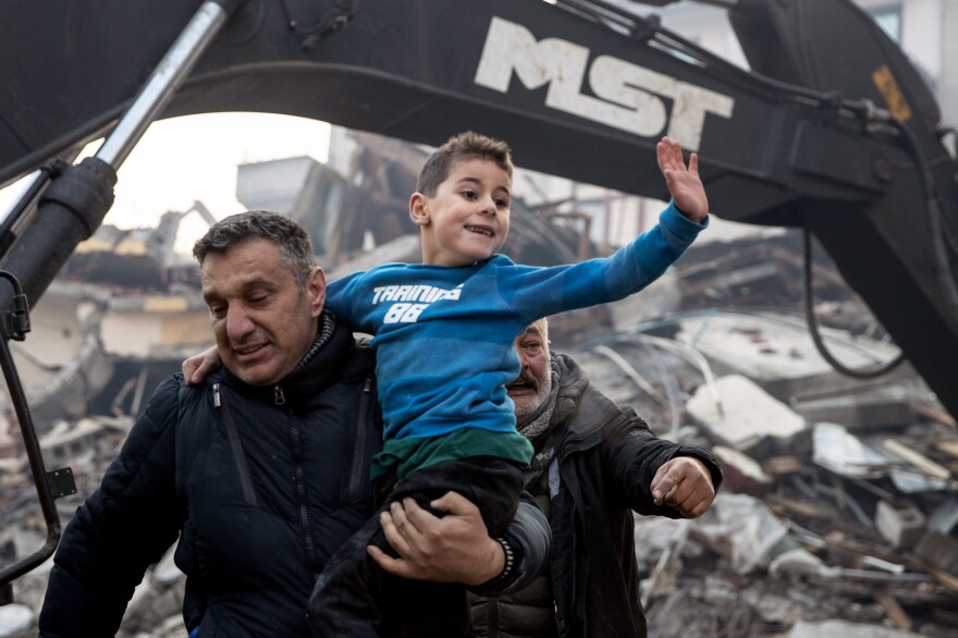 Rescue workers carry 8-year-old survivor, Yigit, at the site of a collapsed building in Hatay, Turkey on Wednesday. He was rescued 52 hours after an earthquake struck the area on Monday.