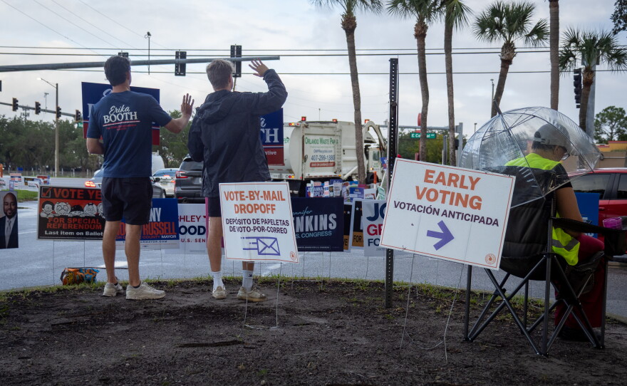 Volunteers with Republican state Rep. Erika Booth’s campaign wave at cars visiting the Alafaya Library Branch in Orange County for early voting on Monday. Booth is the incumbent, representing parts of Orange and Osceola county voters in Florida’s 35th state House district.