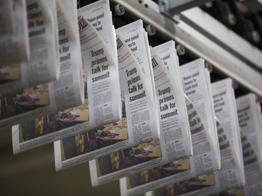 A daily edition of <em>The Columbian</em> passes overhead at the paper's printing press in Vancouver, Wash.