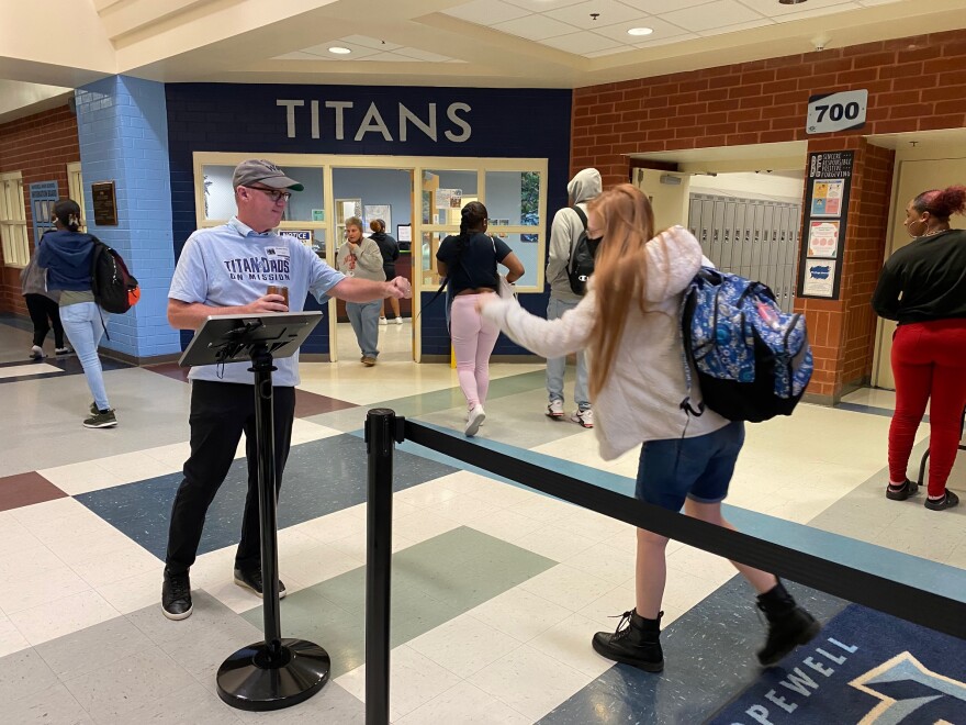 Pastor Mike Moses greets a Hopewell student while keeping an eye on the screen that will flag any metal in book bags.