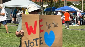 A participant holds a sign at the No Dictators rally at the Hawaiʻi State Capitol on Oct. 17, 2026.