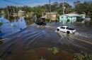 Vehicles drive through flood waters in the aftermath of Hurricane Milton in Lake Maggiore in St. Petersburg in 2025.