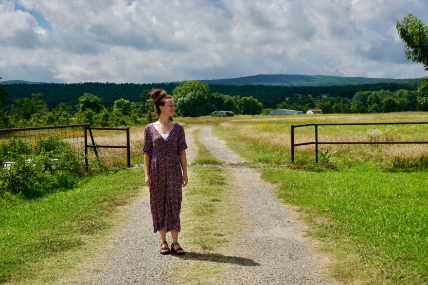 Jess Bray stands on the dirt road leading into Blue Mountain Farm, which she operates near McCurtin, Oklahoma, on June 17, 2024